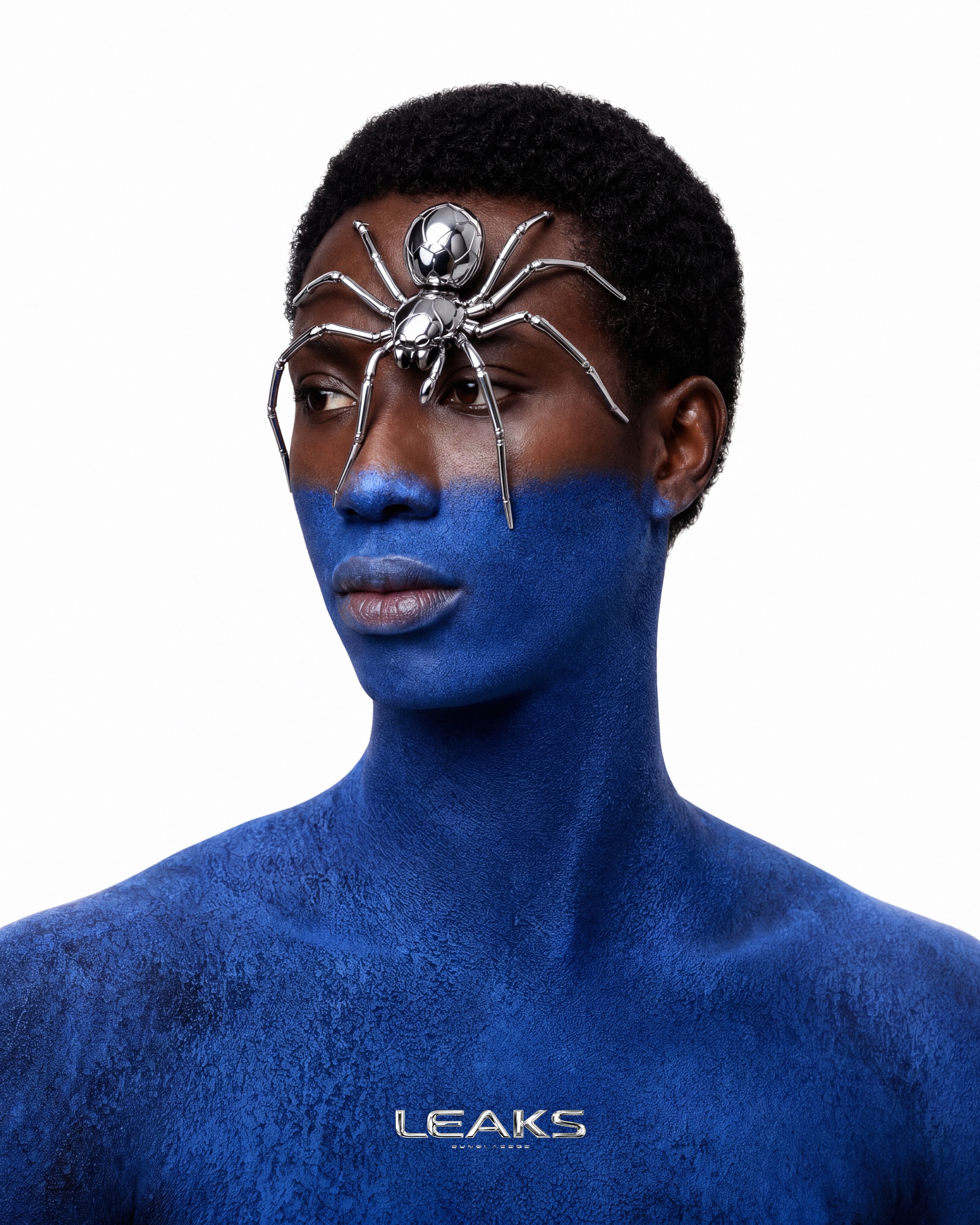 Portrait bleu — araignée chromée posée sur le visage, teaser du Drop 001